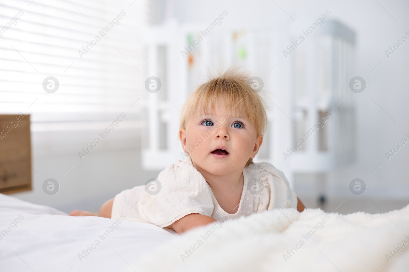Photo of Cute little baby on bed in room