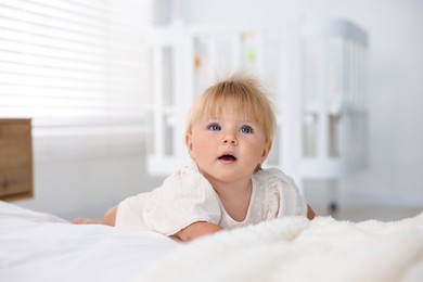 Photo of Cute little baby on bed in room