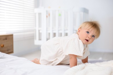 Photo of Cute little baby on bed in room