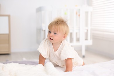 Photo of Cute little baby on bed in room