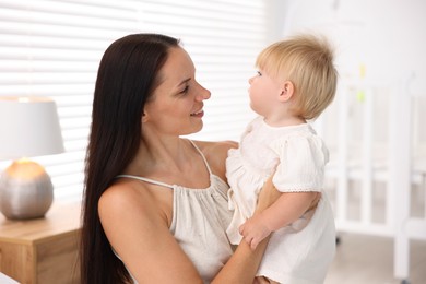 Photo of Mother and her cute little baby in room