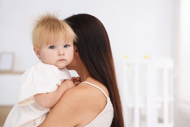 Photo of Mother and her cute little baby in room, space for text