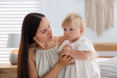 Photo of Mother and her cute little baby on bed in room