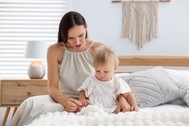 Photo of Mother and her cute little baby on bed in room