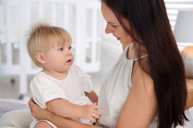 Photo of Mother and her cute little baby on bed in room