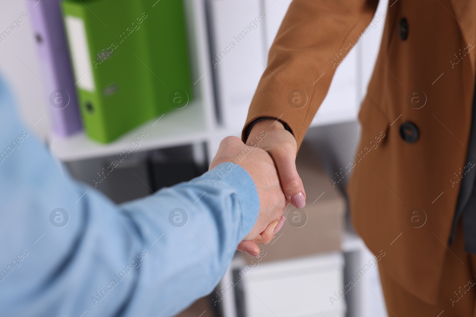 Photo of Business partners shaking hands in office, closeup