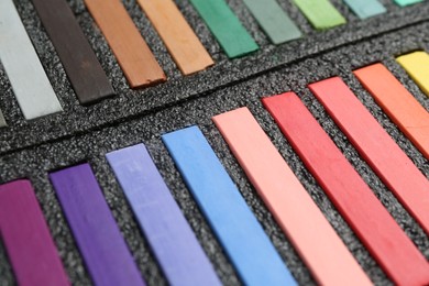 Photo of Set of colorful chalk pastels in box, closeup