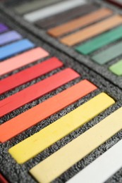 Photo of Set of colorful chalk pastels in box, closeup