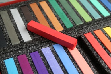 Photo of Set of colorful chalk pastels in box, closeup