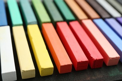 Photo of Set of colorful chalk pastels on table, closeup