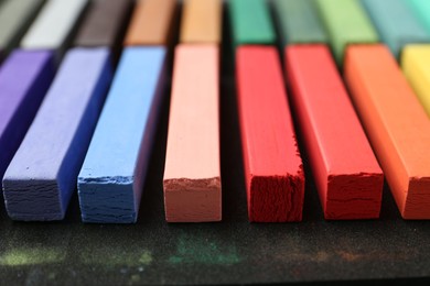Photo of Set of colorful chalk pastels on table, closeup