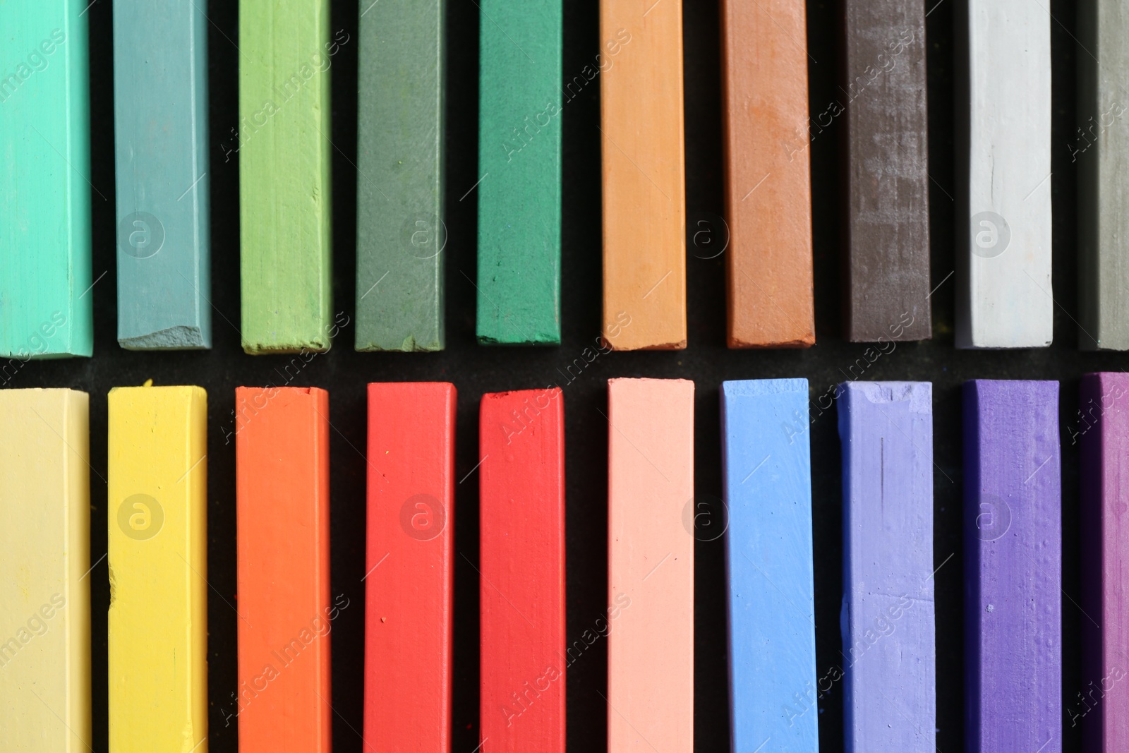 Colorful chalk pastels on black table, top view Photo of Colorful chalk pastels on black table, top view