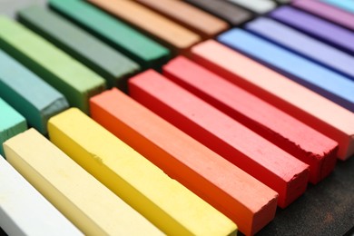 Photo of Set of colorful chalk pastels on table, closeup