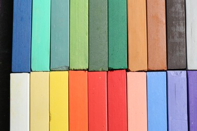 Photo of Colorful chalk pastels as background, top view