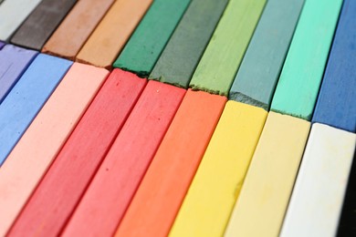 Photo of Set of colorful chalk pastels as background, closeup