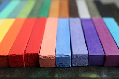 Photo of Set of colorful chalk pastels on table, closeup