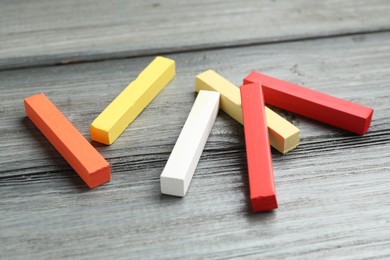 Photo of Colorful chalk pastels on wooden table, closeup