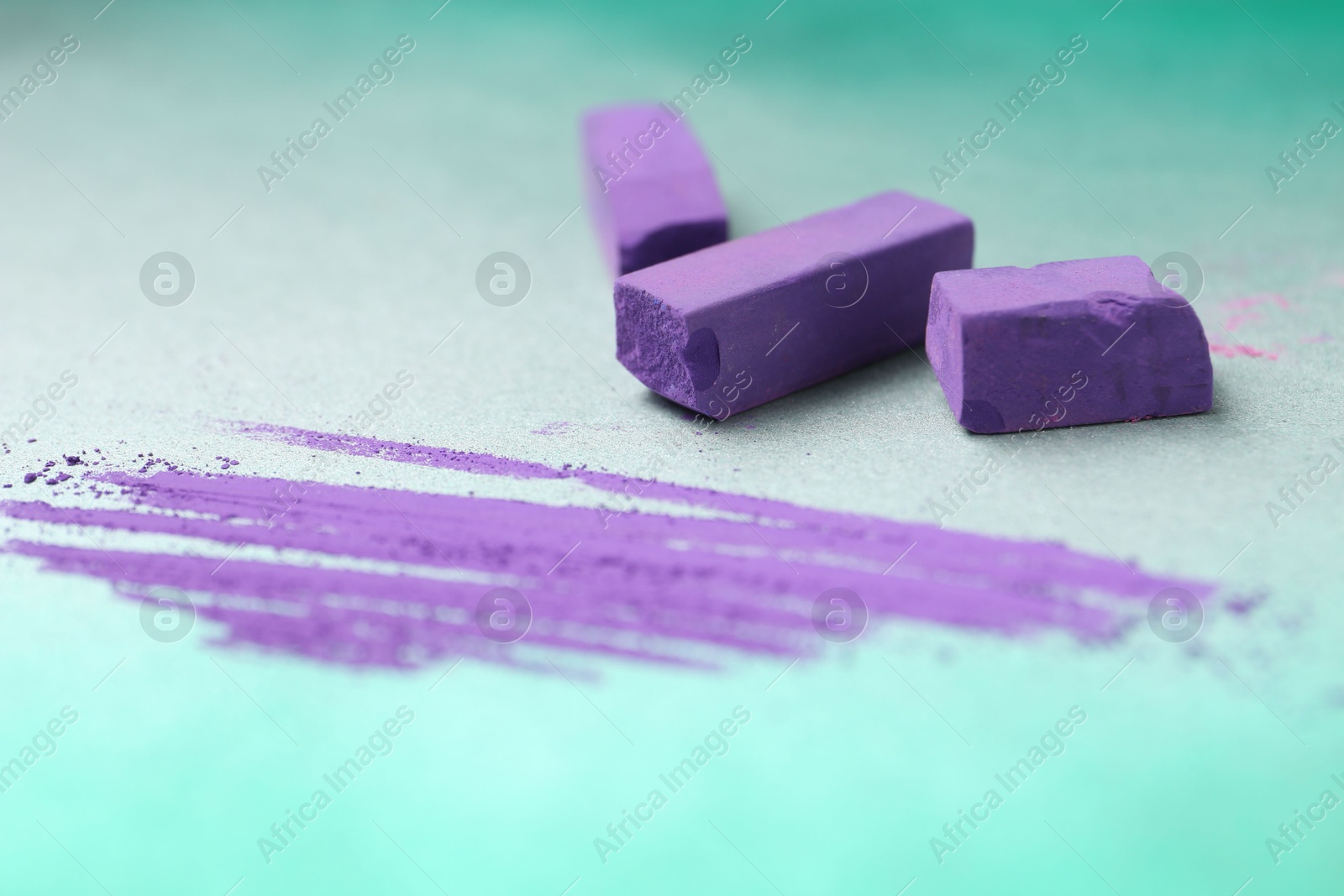 Photo of Violet chalk pastels and scribble on color background, closeup