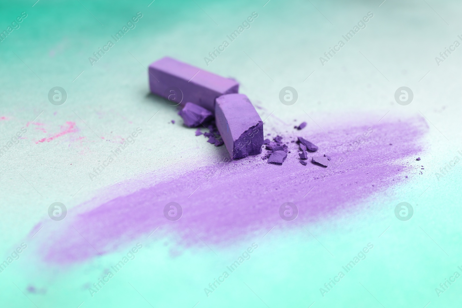 Photo of Violet chalk pastels and scribble on color background, closeup