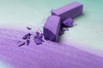 Photo of Violet chalk pastels and scribble on color background, closeup