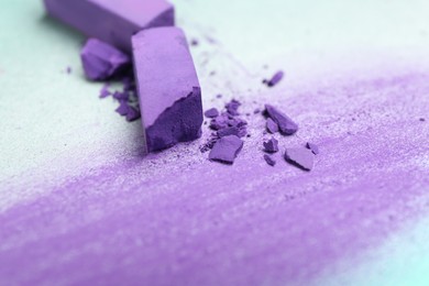 Photo of Violet chalk pastels and scribble on color background, closeup
