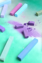 Photo of Colorful chalk pastels on color background, closeup