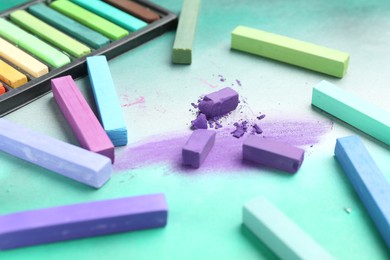 Photo of Colorful chalk pastels on color background, closeup