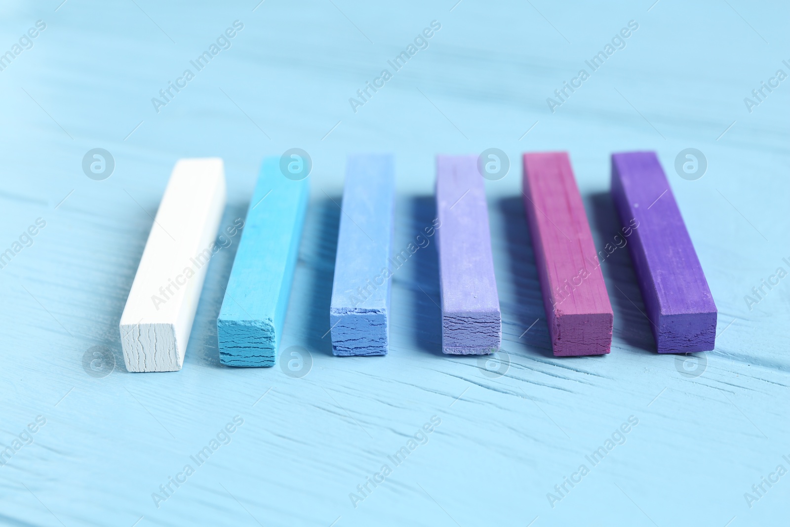 Colorful chalk pastels on light wooden table, closeup Photo of Colorful chalk pastels on light wooden table, closeup