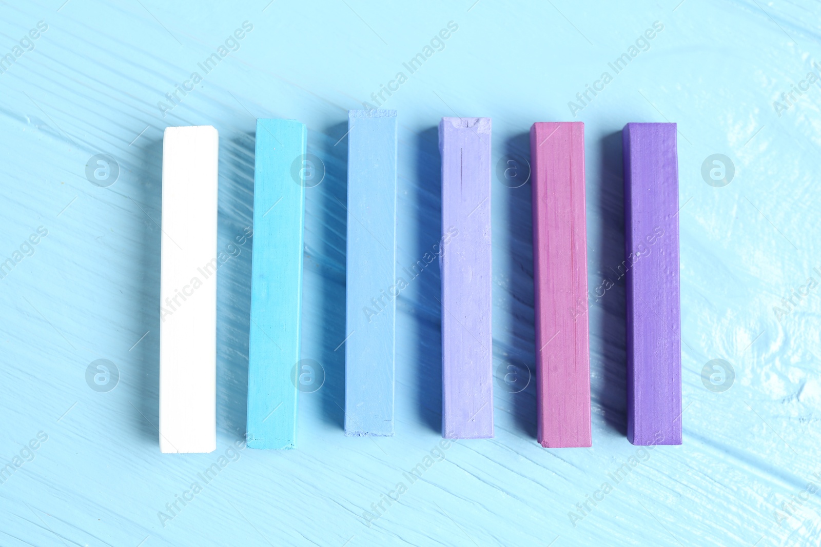 Colorful chalk pastels on light wooden table, flat lay Photo of Colorful chalk pastels on light wooden table, flat lay