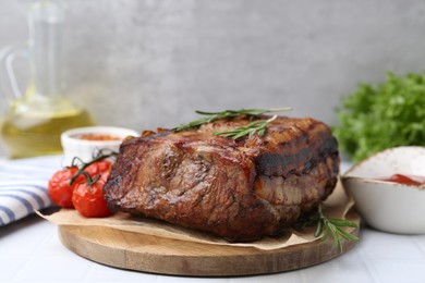 Photo of Delicious roast beef with rosemary and tomatoes on light table, closeup