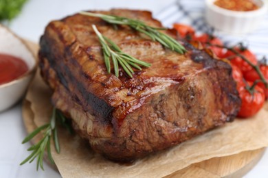 Photo of Delicious roast beef with rosemary and tomatoes on table, closeup