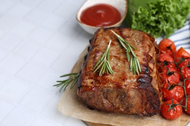 Photo of Delicious roast beef with rosemary, tomatoes, sauce and lettuce on white tiled table, closeup. Space for text