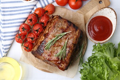 Photo of Delicious roast beef with rosemary, tomatoes and other products on table, flat lay