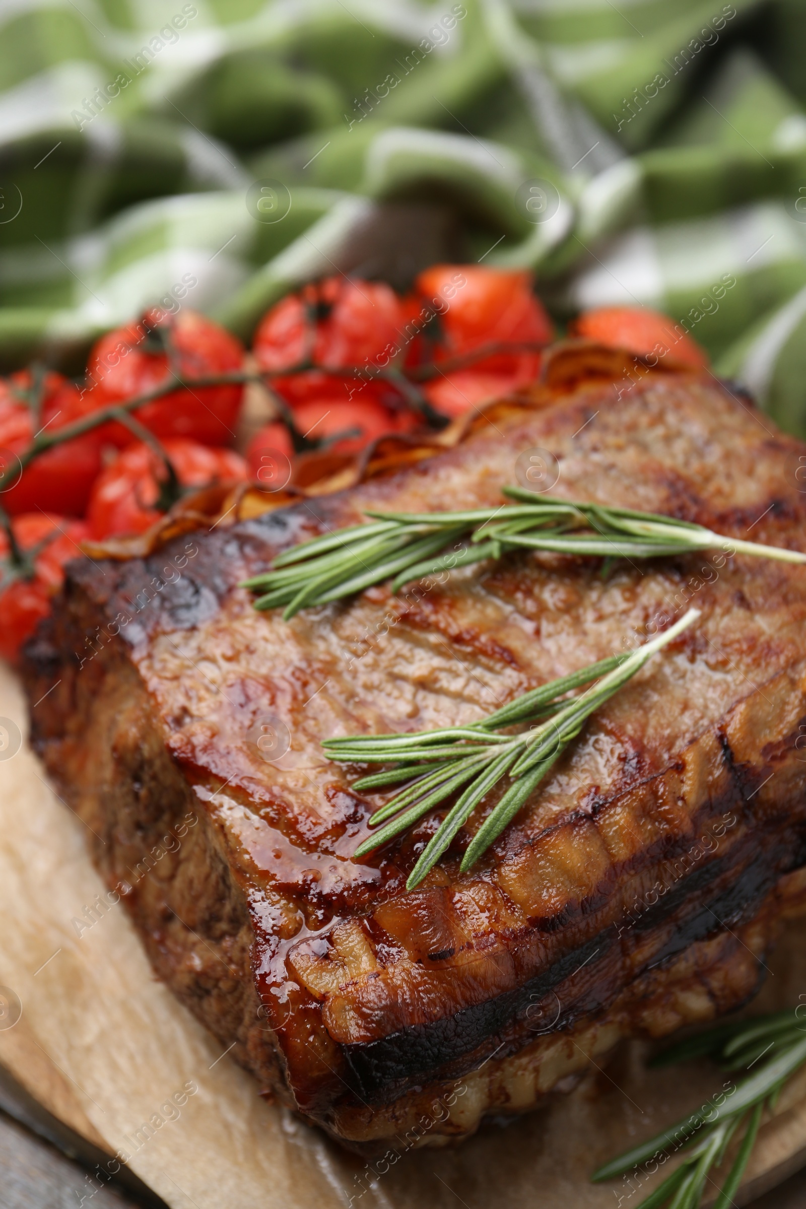 Photo of Delicious roast beef with rosemary and tomatoes on table, closeup