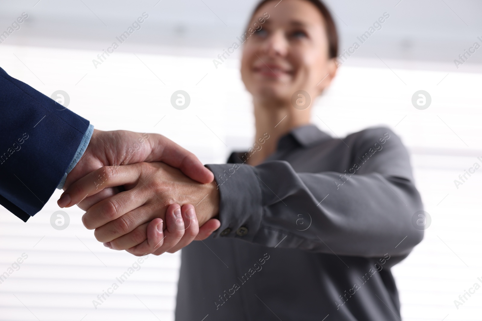 Business partners shaking hands indoors, selective focus Photo of Business partners shaking hands indoors, selective focus