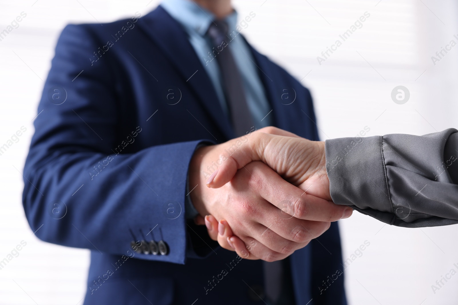 Business partners shaking hands indoors, closeup view Photo of Business partners shaking hands indoors, closeup view
