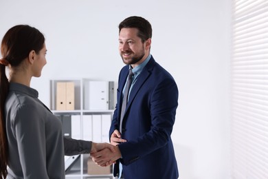 Photo of Business partners shaking hands in office, space for text