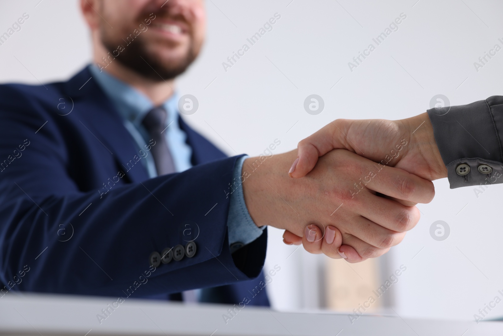 Photo of Business partners shaking hands in office, selective focus