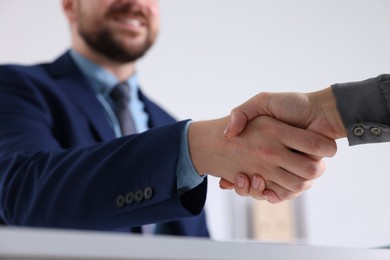 Photo of Business partners shaking hands in office, selective focus