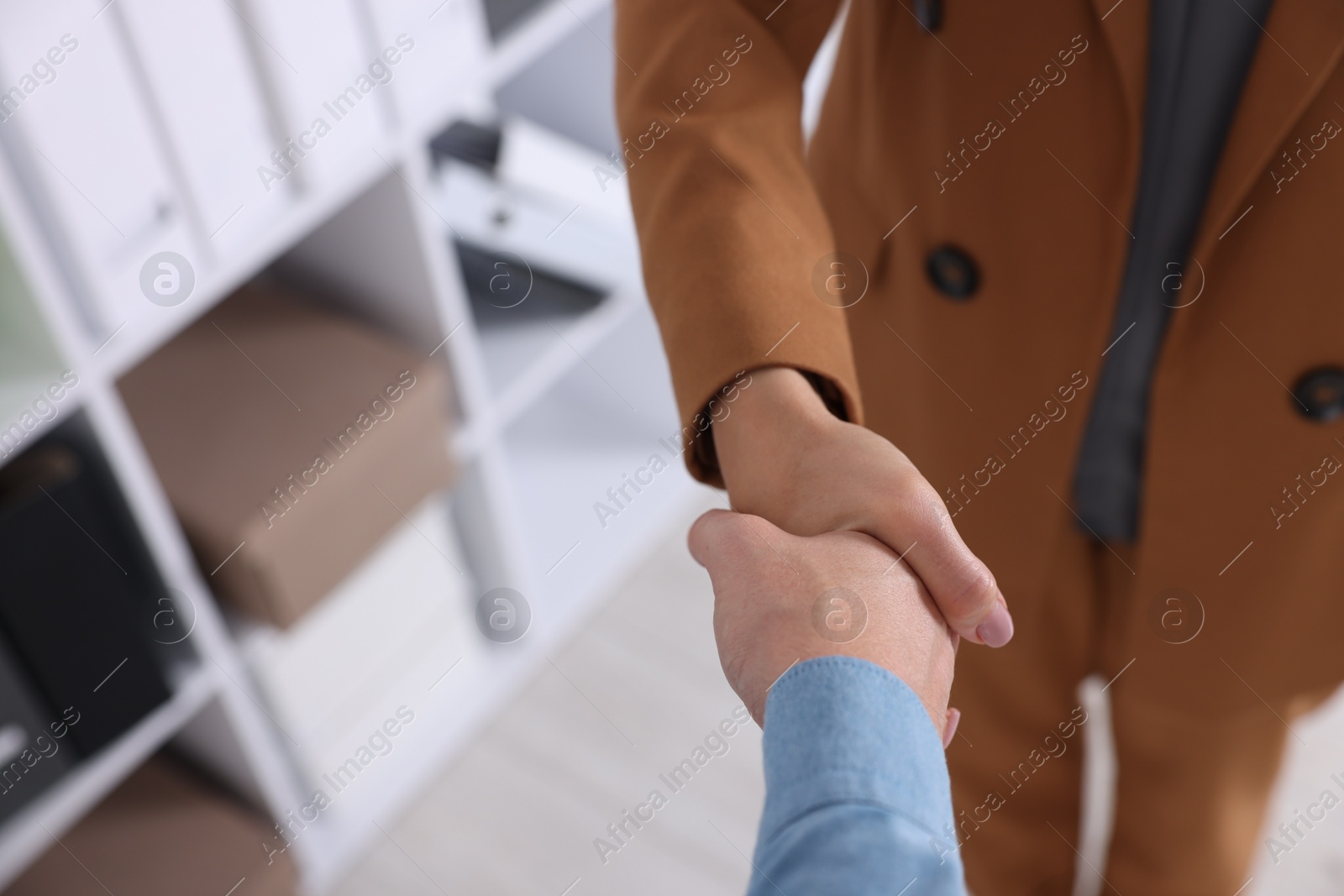 Business partners shaking hands in office, above view. Space for text Photo of Business partners shaking hands in office, above view. Space for text