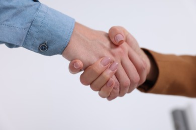 Photo of Business partners shaking hands in office, closeup