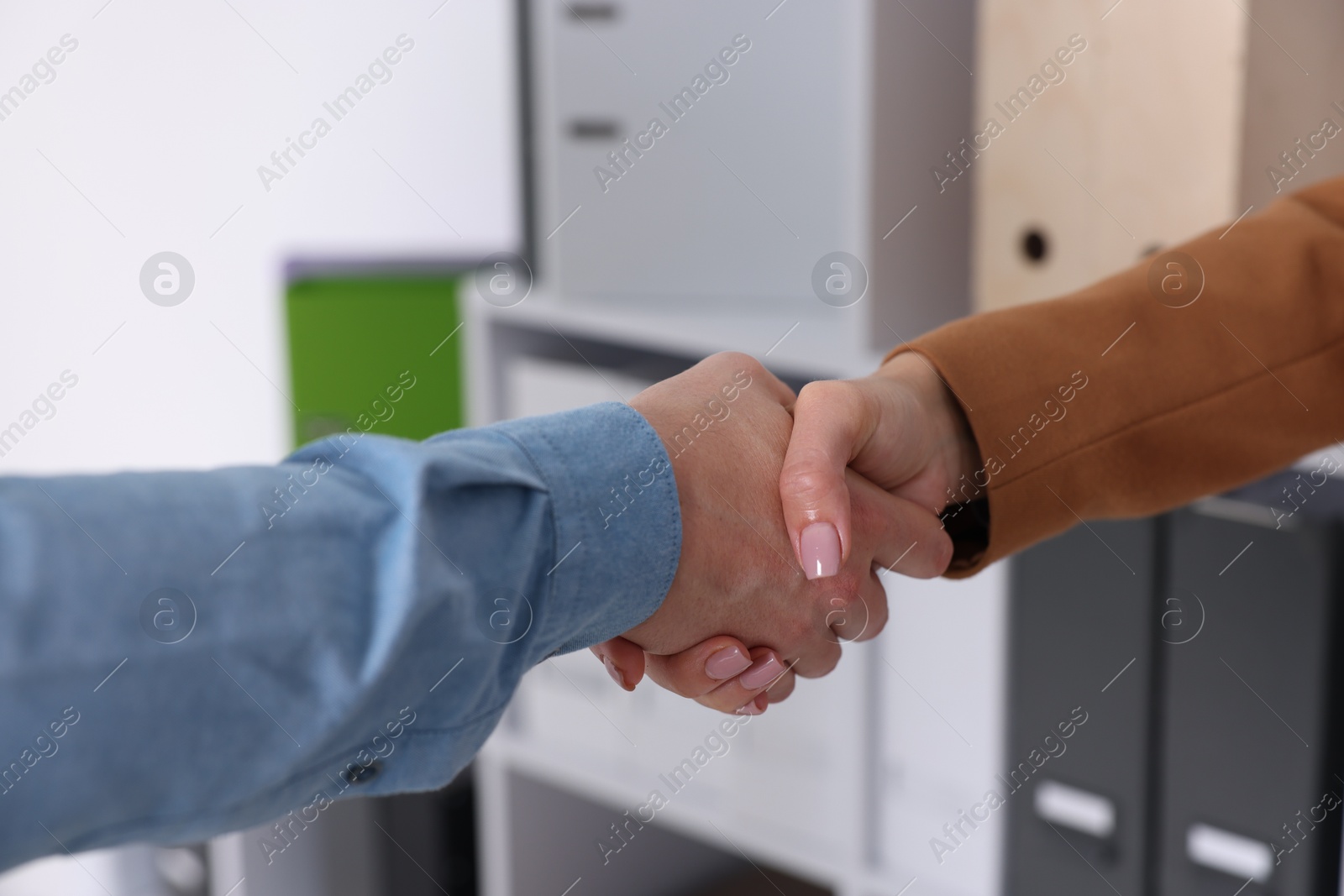 Photo of Business partners shaking hands in office, closeup
