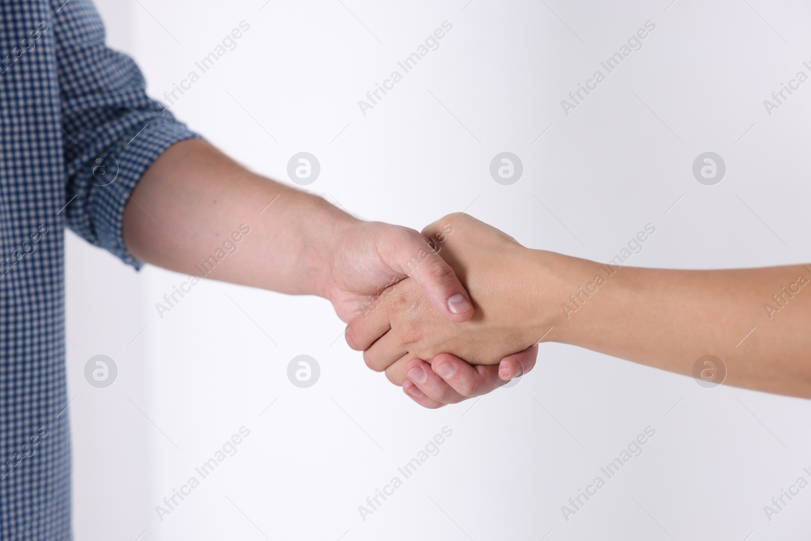 Photo of Man and woman shaking hands near window indoors, closeup