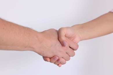 Photo of Man and woman shaking hands near window indoors, closeup