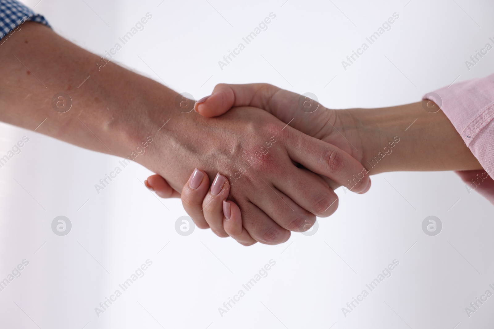 Photo of Man and woman shaking hands near window indoors, closeup