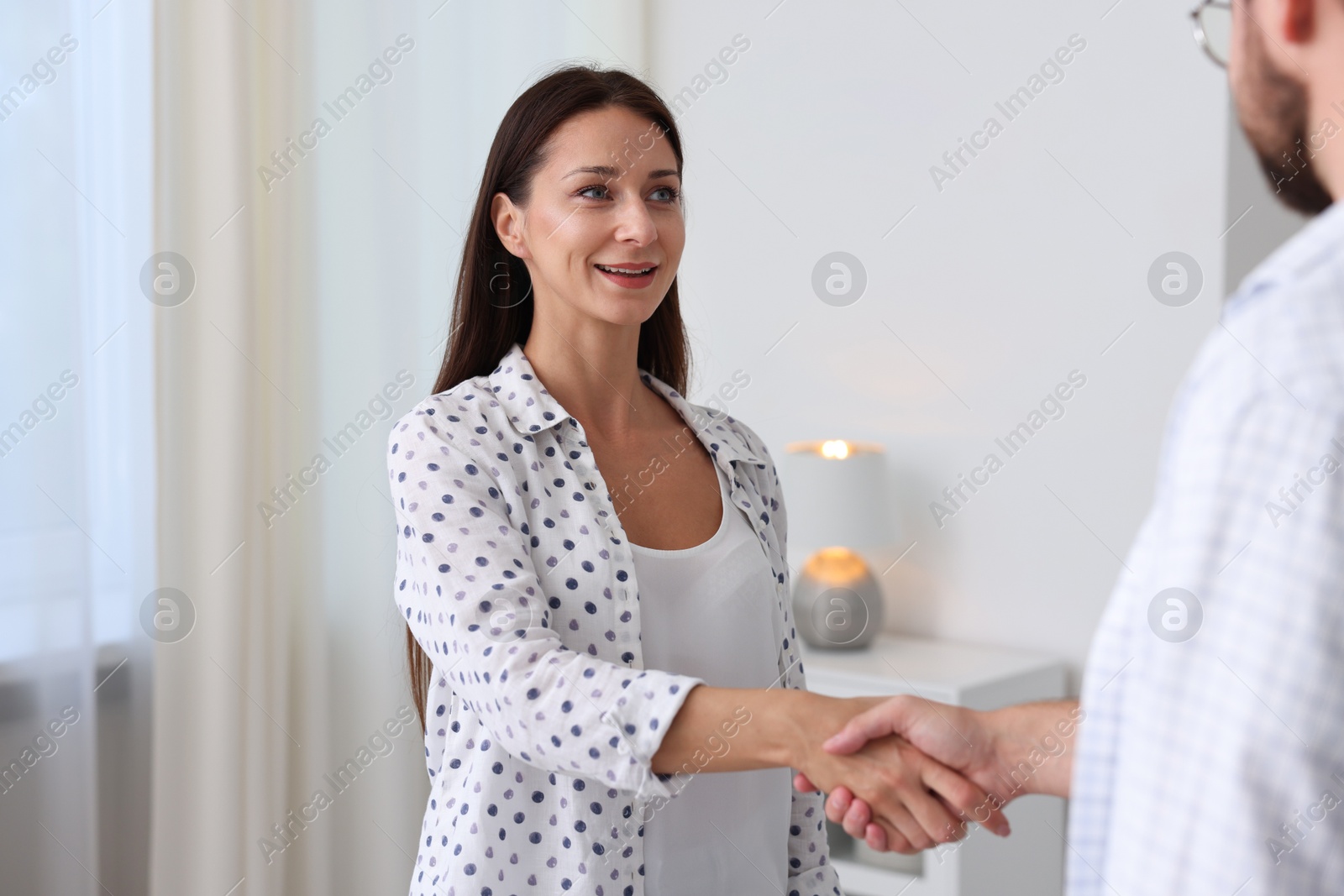 Man and woman shaking hands indoors. Business meeting Photo of Man and woman shaking hands indoors. Business meeting