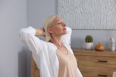 Photo of Beautiful mature woman stretching at workplace. Healthy leisure