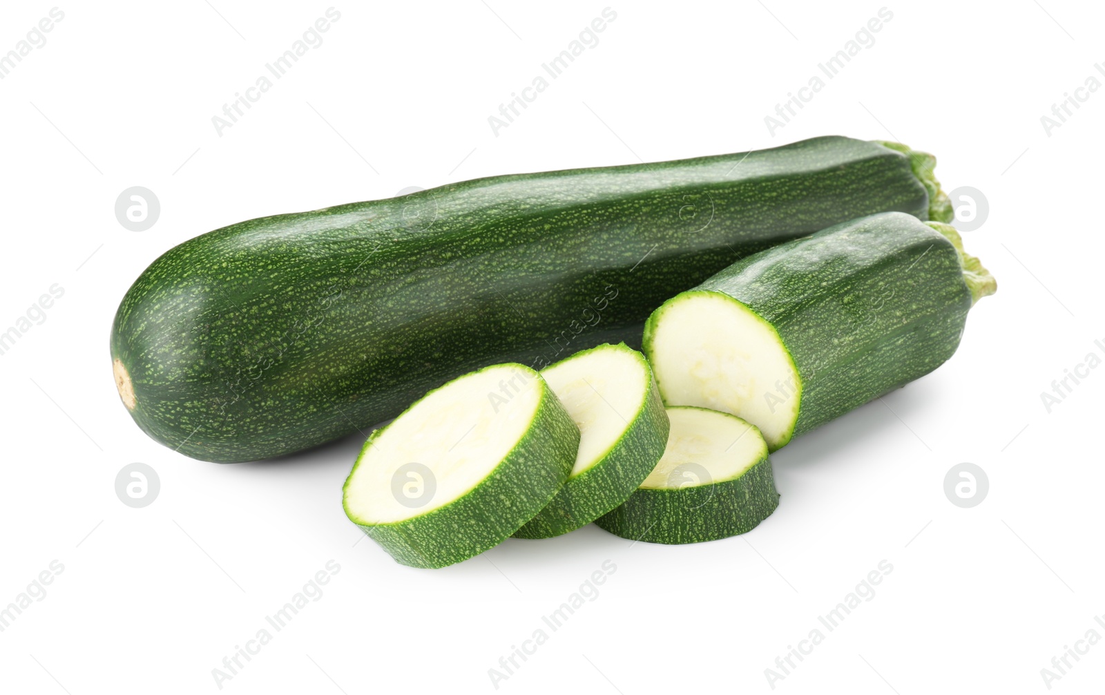 Whole and cut fresh zucchinis isolated on white Photo of Whole and cut fresh zucchinis isolated on white