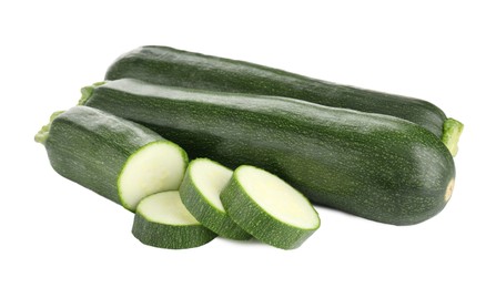 Photo of Whole and cut fresh zucchinis isolated on white
