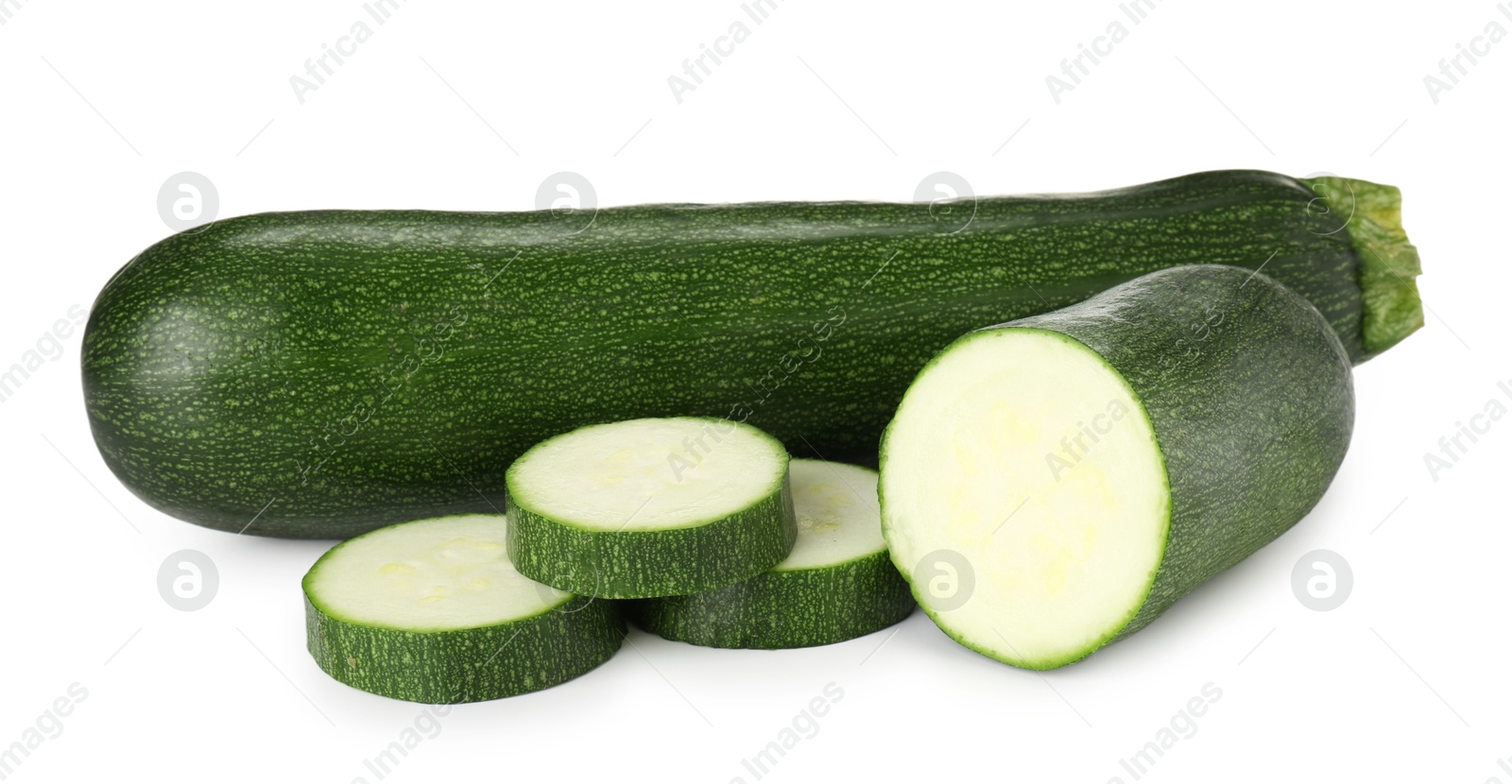 Whole and cut fresh zucchinis isolated on white Photo of Whole and cut fresh zucchinis isolated on white